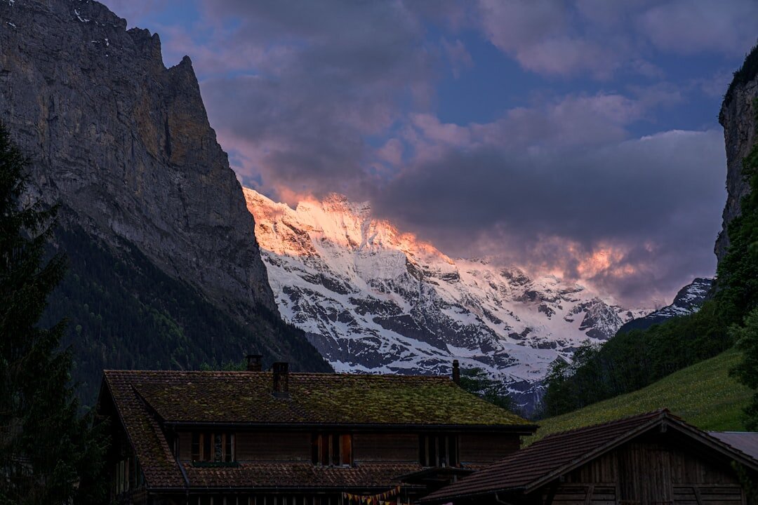 Luxury Swiss chalet exterior at dusk with wooden facade and warm lighting
